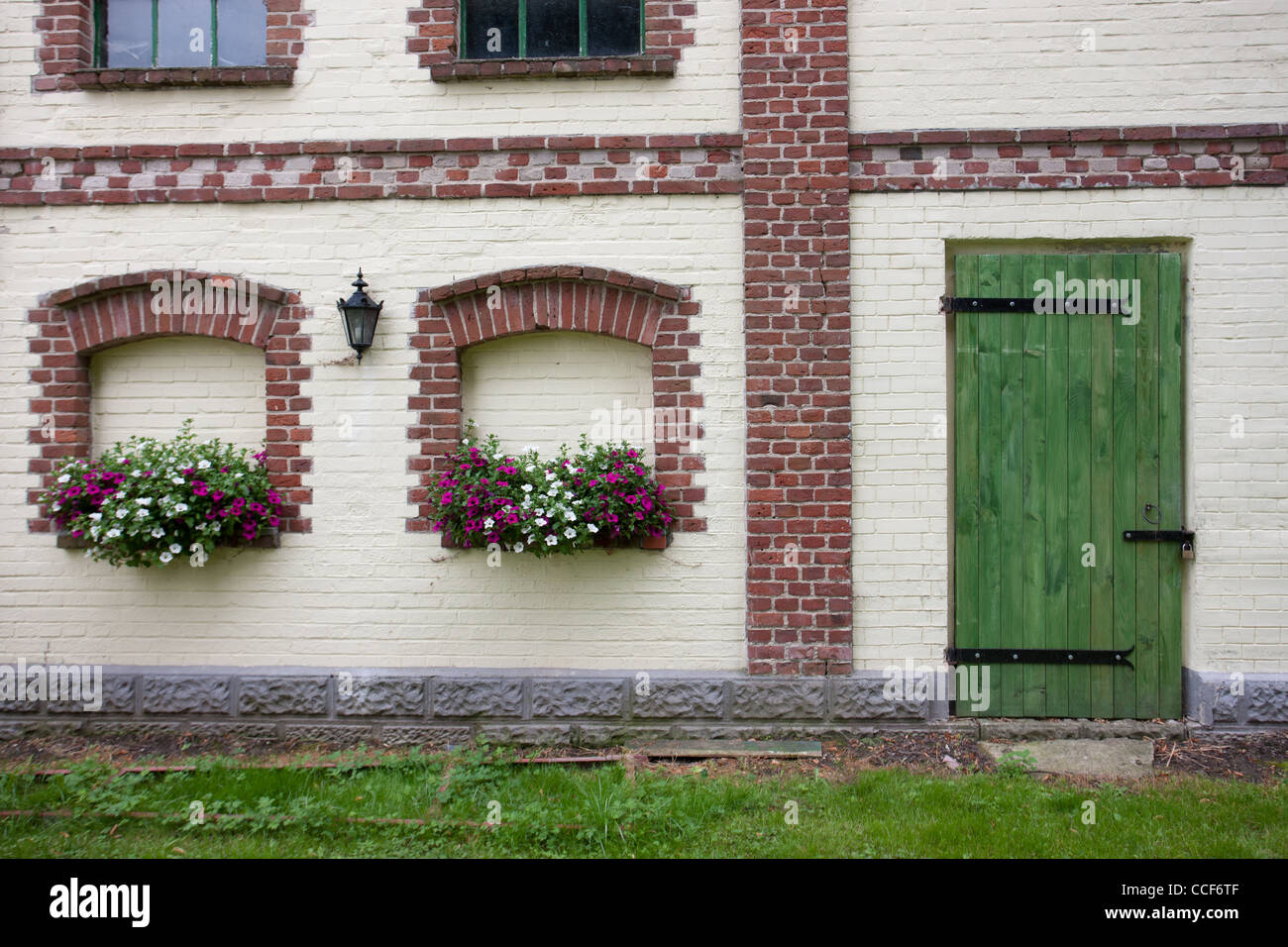 Türen und Fensterläden in Scheune Gebäude. Scheune im Palast in der Stadt von Trzyglow. Blumen auf den Fensterbänken. Stockfoto