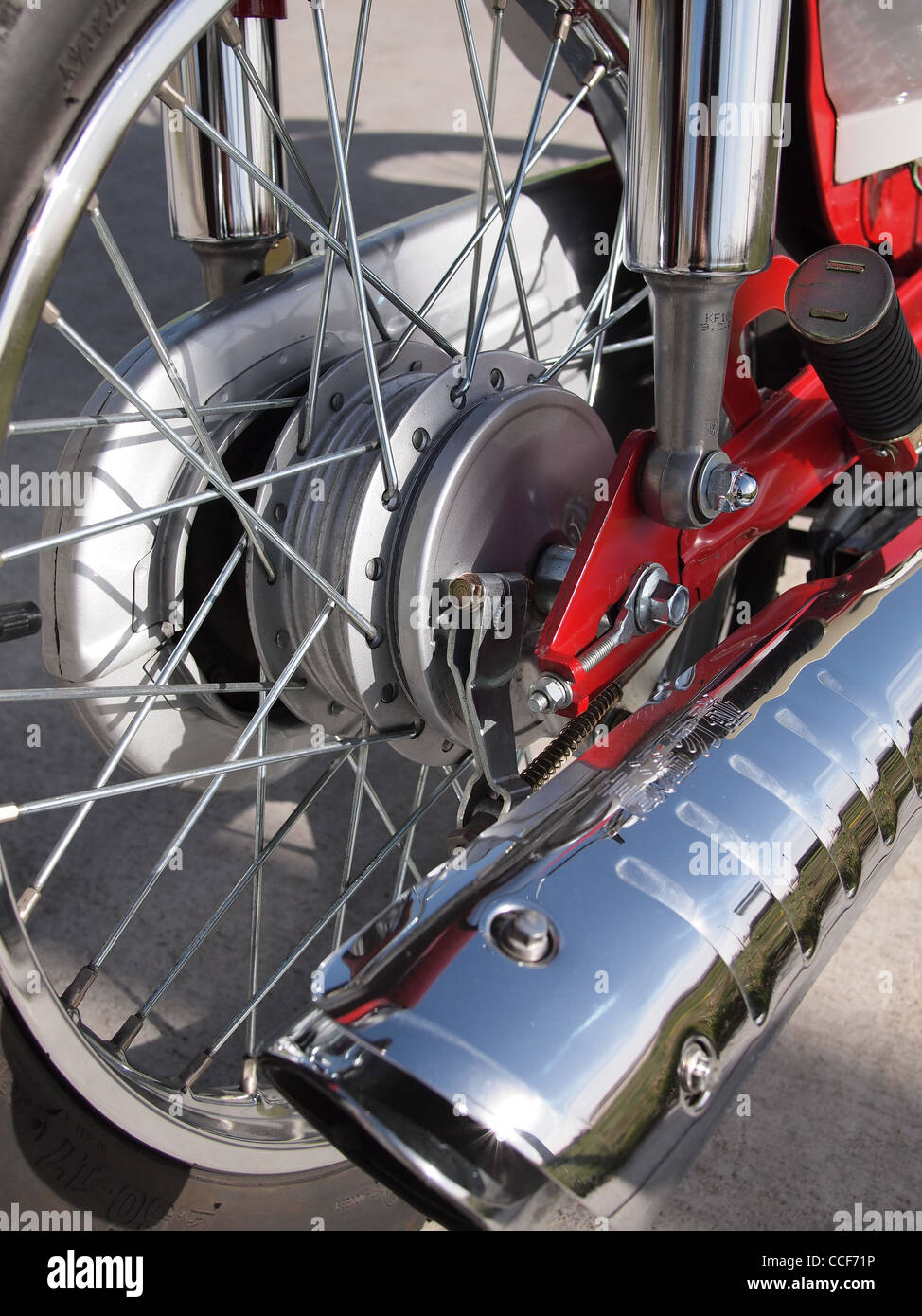 Hinterrad und Auspuff eines roten Mopeds Stockfoto