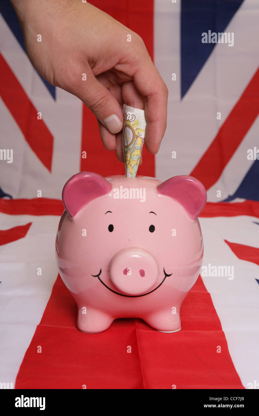Speichern von zehn Pfund mit Sparschwein auf Union jack Stockfoto