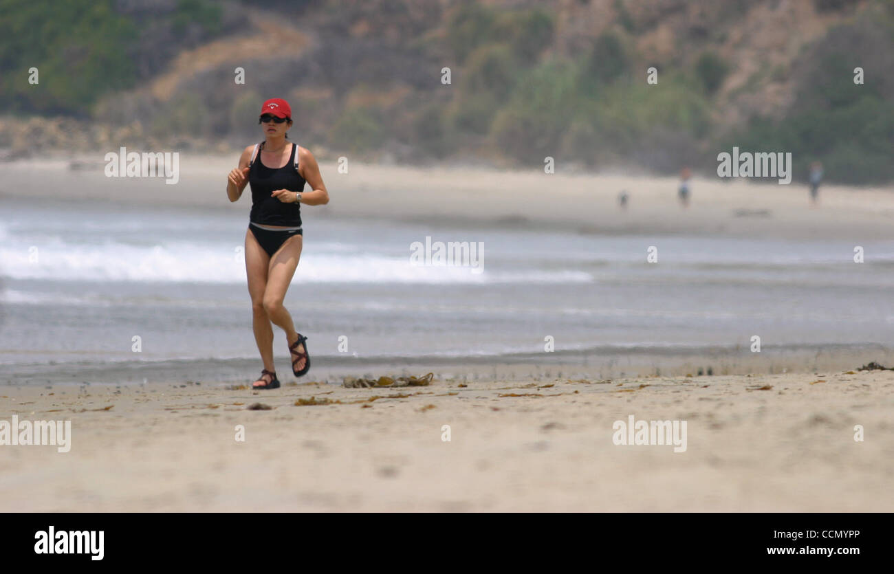17. Juli 2004; Salt Creek, Kalifornien, USA; Eine junge Frau bekommt Übung durch Joggen am Meer am Strand von Salt Creek im Orange County. Im Gegensatz dazu viel Essen und mangelnde Bewegung könnte Rauchen als die häufigste Ursache für vermeidbare Todesfälle unter den Amerikanern bis 2005 überholen. Stockfoto