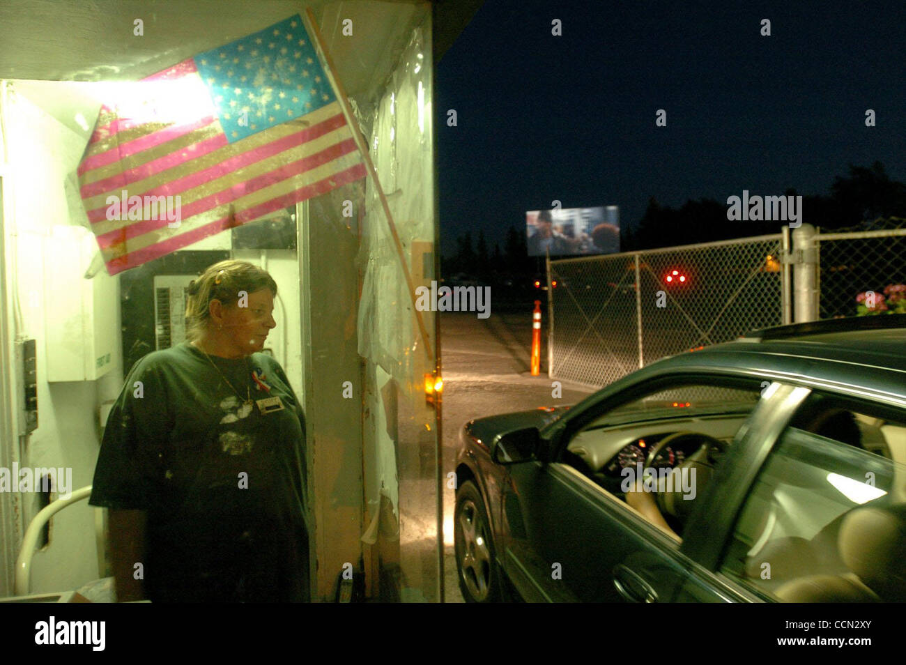 21:05: Linda Alley, der den Eintritt ins Kino einsammelt, im Gespräch mit Menschen beim Eintritt in den Solano Drive-in Kino auf Donnerstag, 22. Juli 2004 in Concord, Kalifornien (Contra Costa Times / Gregory Urquiaga) Stockfoto