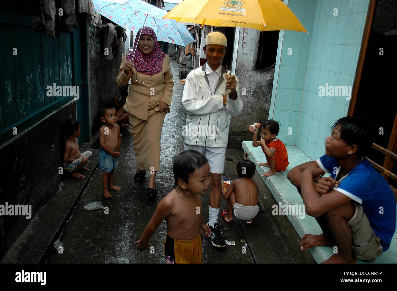 JAKARTA, Indonesien-NOVEMBER 29, Frau Endrizaemi, im Volksmund von "Ibu Haji" geht in der Mitte der Regen auf dem Weg nach Hause von ihrem Studentenhaus, wurde, 2004 von der Schule für Tage abwesend. Neben ihrem Hauptberuf als Leiter des SD Negeri 03 Marunda Grundschule unterrichtet sie auch in Stockfoto