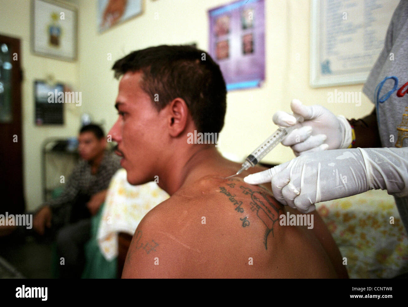 Juan Carlos Lagos, 22, ein ehemaliges Gang-Mitglied erhält einen Schuss der Anästhesie in einer San Pedro Sula, Honduras, Tattoo-Entfernung-Klinik.   Fotograf: Luis J. Jimenez Stadt: San Pedro Sula Country: Honduras Datum: 10. Juni 2004 Stockfoto