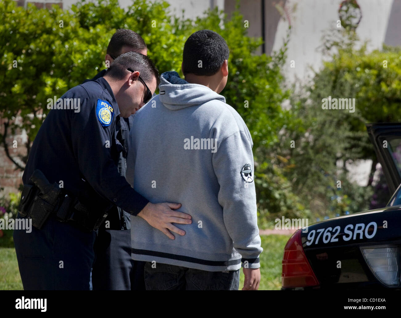 THIRD--A Hiram Johnson Student wird von einem Polizisten der Stadt von Freeport Blvd. in Gewahrsam genommen, weil er offiziell Schwänzen nach Angaben der Polizei ist. (Ca. 35 Studenten wurden in Gewahrsam genommen). Er war mit 56 andere Hiram Johnson Schülerinnen und Schüler, die aus ihrer Schule zu Cesar C marschierten Stockfoto