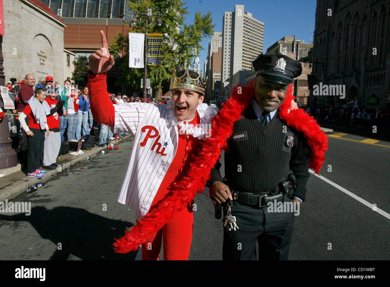 31. Oktober 2008 stellt - Philadelphia, Pennsylvania, USA - TYLER LOVE, links, seine Boa um Philadelphia Polizist MIKE GOODE, als er die Menschenmenge vor dem Start der Phillies World Series Siegesparade fordert, auf. (Kredit-Bild: © Charles Fox/Philadelphia DailyNews/ZUMA Press) Stockfoto