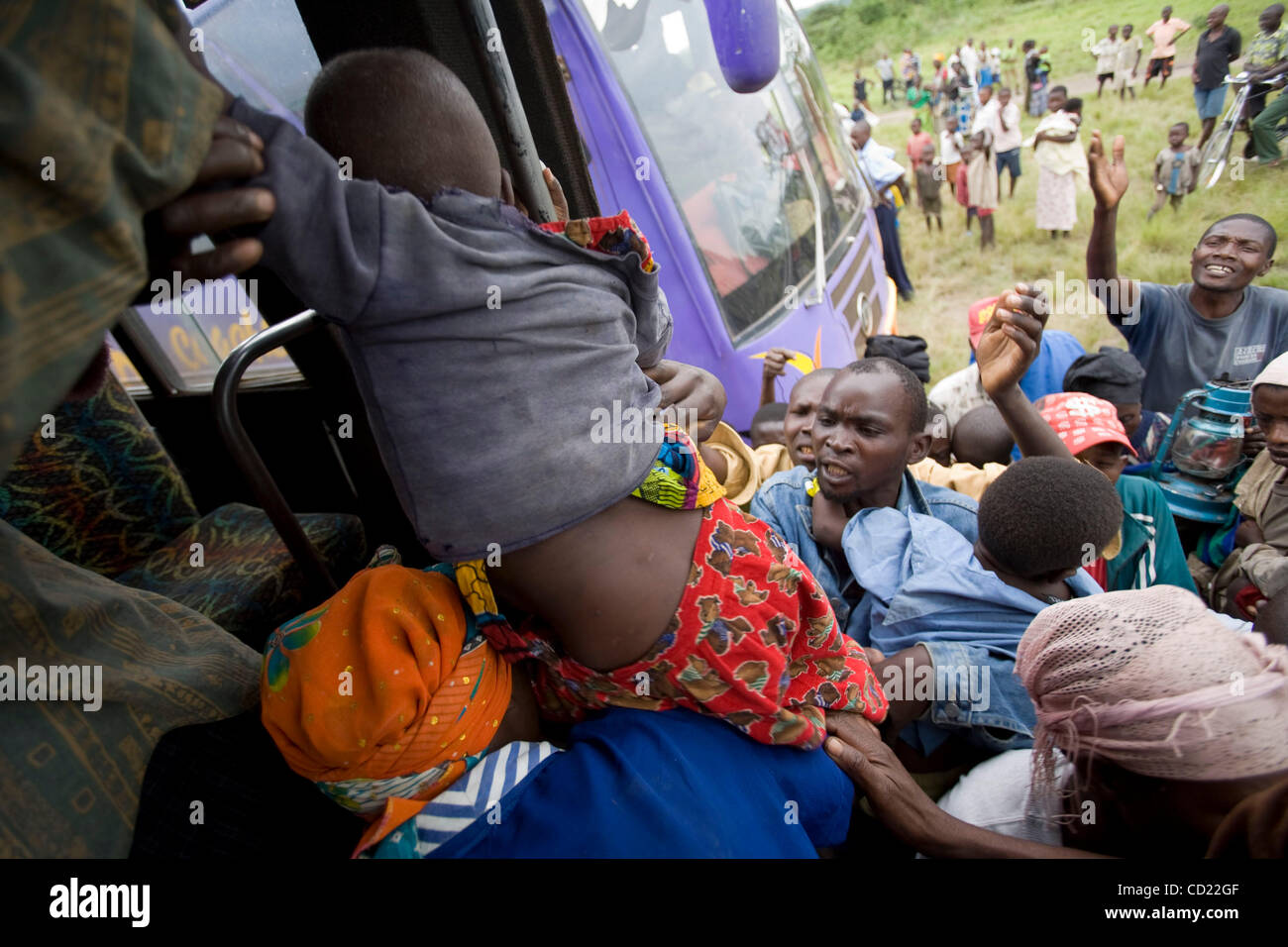 Ein Kind ist in einen Bus aufgehoben, denn kongolesische Flüchtlinge Stelle auf einem der Busse eine UNHCR holding Zentrum für die Flüchtlingslager in Nakivale auf Donnerstag, 13. November 2008 in Ishasha, Uganda, drängeln. UNHCR registriert 440 neue Flüchtlinge an der Holding-Center, darunter 194 Familien. (Foto von t.j. Stockfoto