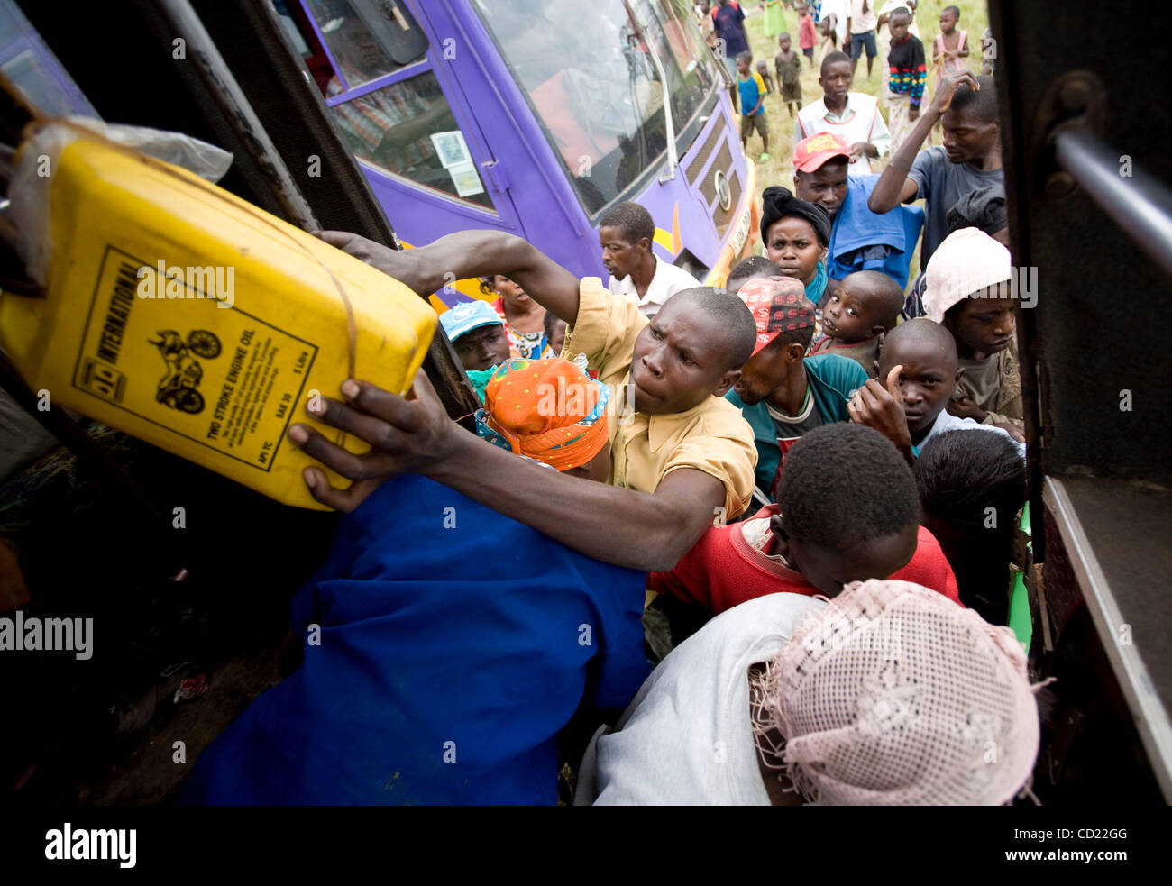Ein kongolesischer Mann versucht einen Kanister in einen Bus übergeben, wie Flüchtlinge Stelle auf einem der Busse eine UNHCR holding Zentrum für die Flüchtlingslager in Nakivale auf Donnerstag, 13. November 2008 in Ishasha, Uganda, drängeln. UNHCR registriert 440 neue Flüchtlinge an der Holding-Center, darunter 194 Familien. ( Stockfoto