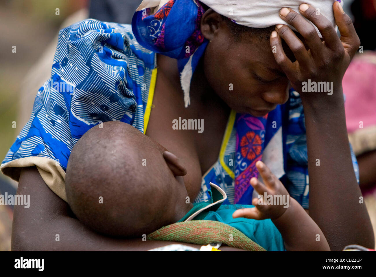 Eine kongolesische Frau ruht ihr Kopf bei der Pflege eines ihrer Kinder als Flüchtlinge warten die Busse eine UNHCR Zentrum für die Flüchtlingslager in Nakivale auf Donnerstag, 13. November 2008 in Ishasha, Uganda, halten an Bord. UNHCR registriert 440 neue Flüchtlinge an der Holding-Center, darunter 194 Familien. Stockfoto
