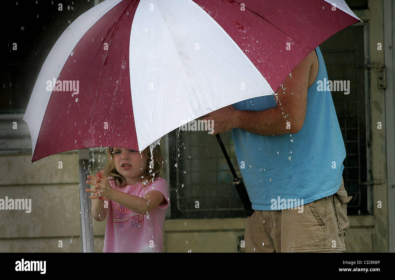 3. Juni 2008 spielt - Mishawaka, Indiana, USA - Leah Holcomb, 6, im Regen auf der Veranda ihres Hauses in Mishawaka, Indiana, als ihr Vater, David, 43, etwas Schutz mit einem Regenschirm bietet.  (Jim Z. Rider/South Bend Tribune, ZUMA Press) Stockfoto
