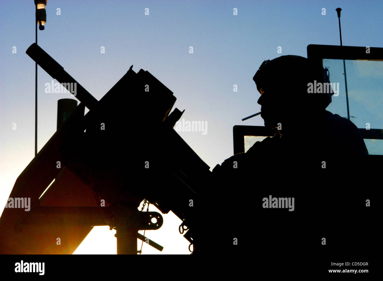 24. April 2008 - Paktya-Provinz, Afghanistan - profiliert im afghanischen Sonnenuntergang, ist entspannt, mit einer Zigarette bereit, Licht, während einer Patrouille Stop der Humvee MK-19 Turret Gunner. Der MK-19, namens Mark neunzehn, ist eine automatische 20mm Granatwerfer. Der Turm hier passiert das Recht auf Stockfoto