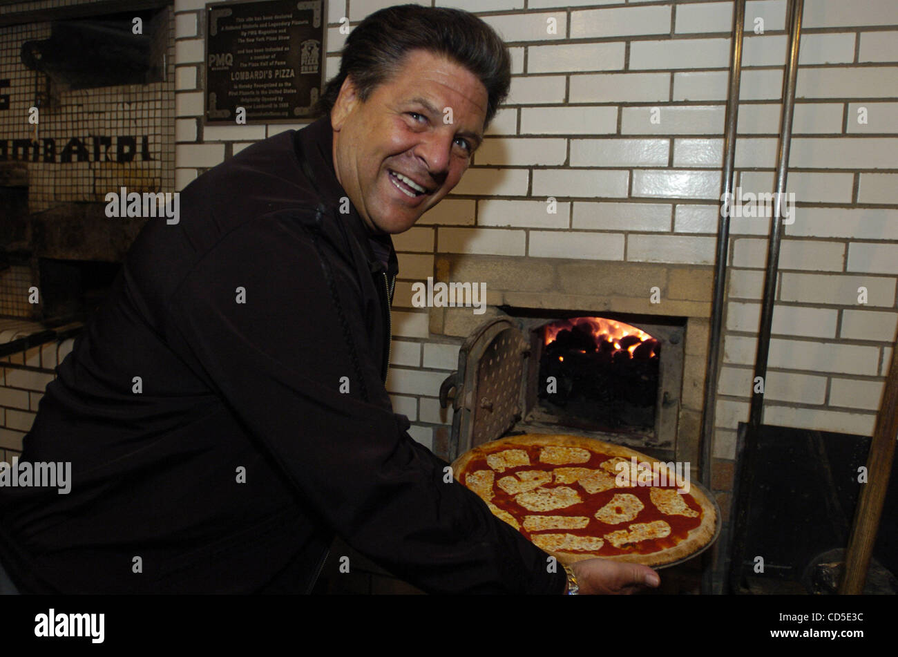 John Brescio, Besitzer des Lombardi es mit einer Pizza aus dem Ofen. Scott  Wiener, 26, von Hoboken, NJ startete Scotts Pizza Touren mit dem Bus, wo  Menschen New Yorks besten Pizzerien getroffen