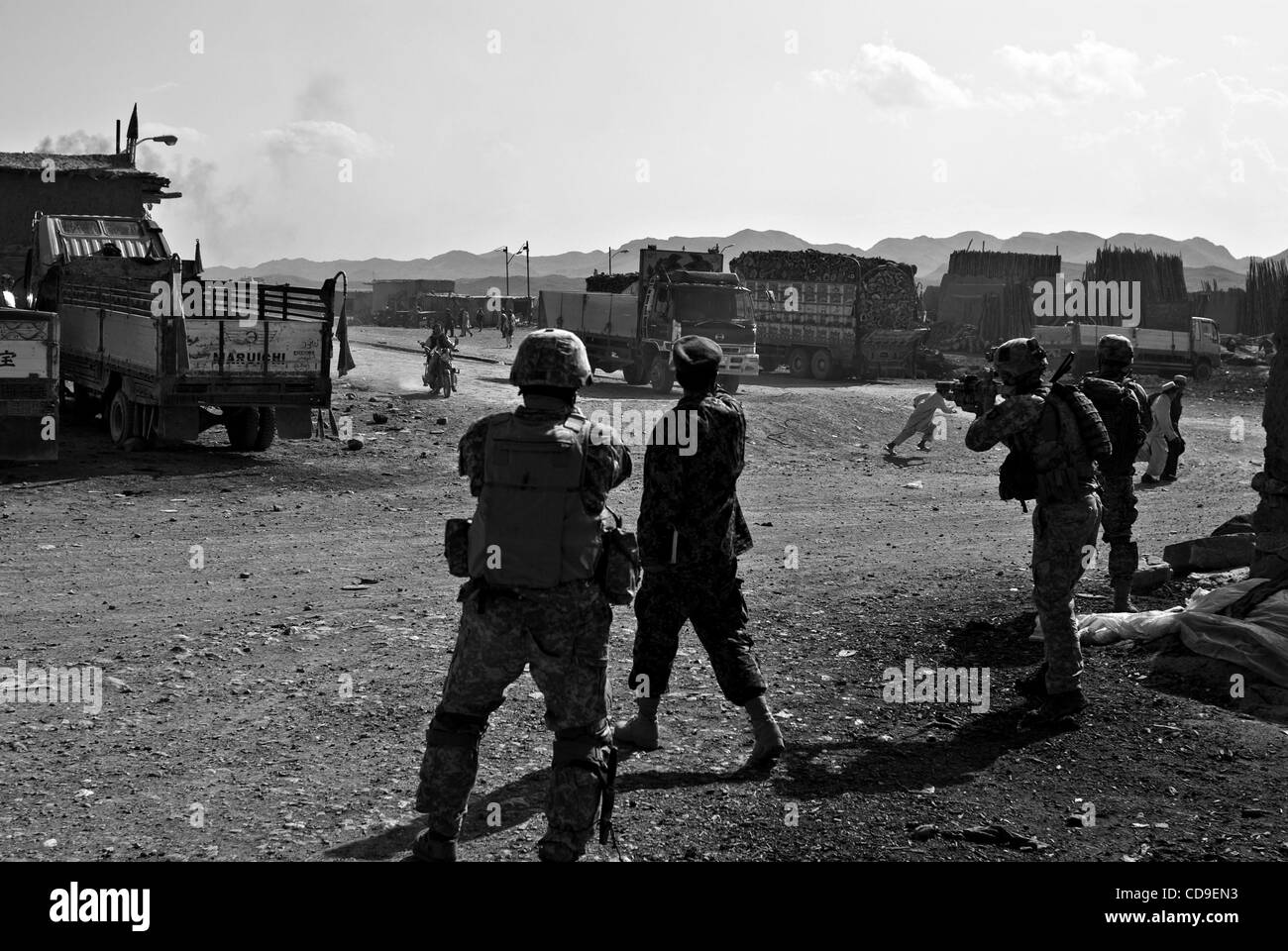 Infanteristen mit Abu Gesellschaft, 1. Bataillon, 187. Infanterie-Regiment, wollen ihre Waffen an einem Motorrad während einer afghanischen Armee Offizier Trys es winken ab, nachdem es um eine Ecke bog und in Richtung einer Fuß-Patrouille durch den Basar raste. Stockfoto