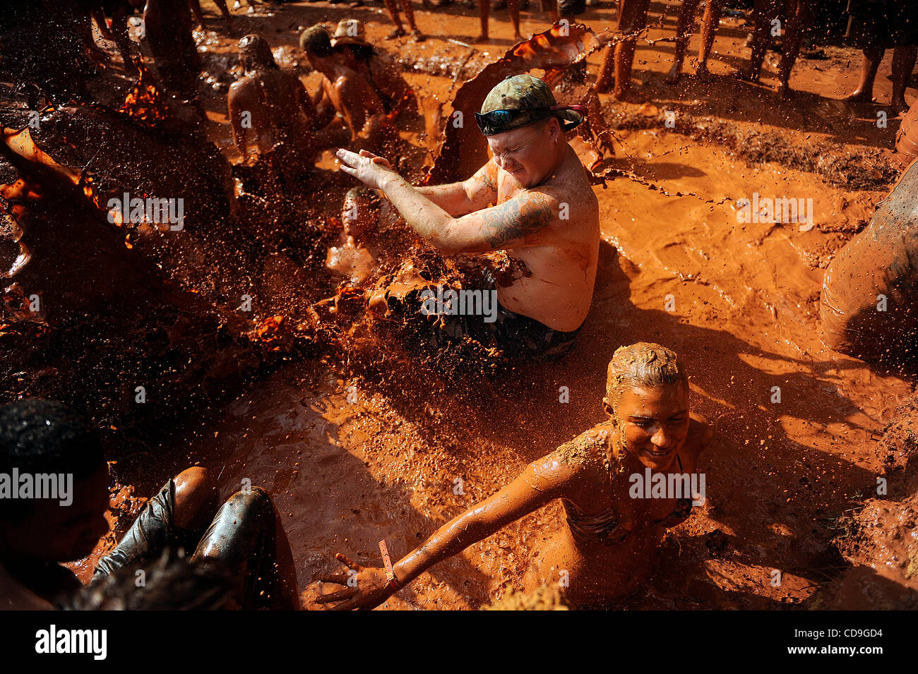 Samstag, 10. Juli 2010 springt EAST DUBLIN, GEORGIA - A Redneck Spiele Teilnehmer über ein Mädchen, wie sie während des Bauchlandung Contest am Buckeye Park während der Redneck Spiele in East Dublin, Georgia im Schlamm wälzt. Die Spiele begannen im Jahr 1996 als Parodie auf die Olympischen Spiele in Atlanta, G statt waren Stockfoto