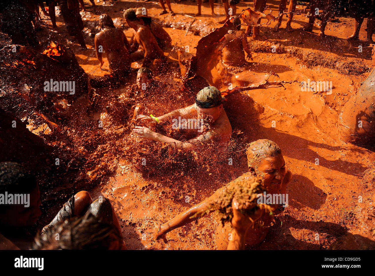 Samstag, 10. Juli 2010 springt EAST DUBLIN, GEORGIA - A Redneck Spiele Teilnehmer über ein Mädchen, wie sie während des Bauchlandung Contest am Buckeye Park während der Redneck Spiele in East Dublin, Georgia im Schlamm wälzt. Die Spiele begannen im Jahr 1996 als Parodie auf die Olympischen Spiele in Atlanta, G statt waren Stockfoto