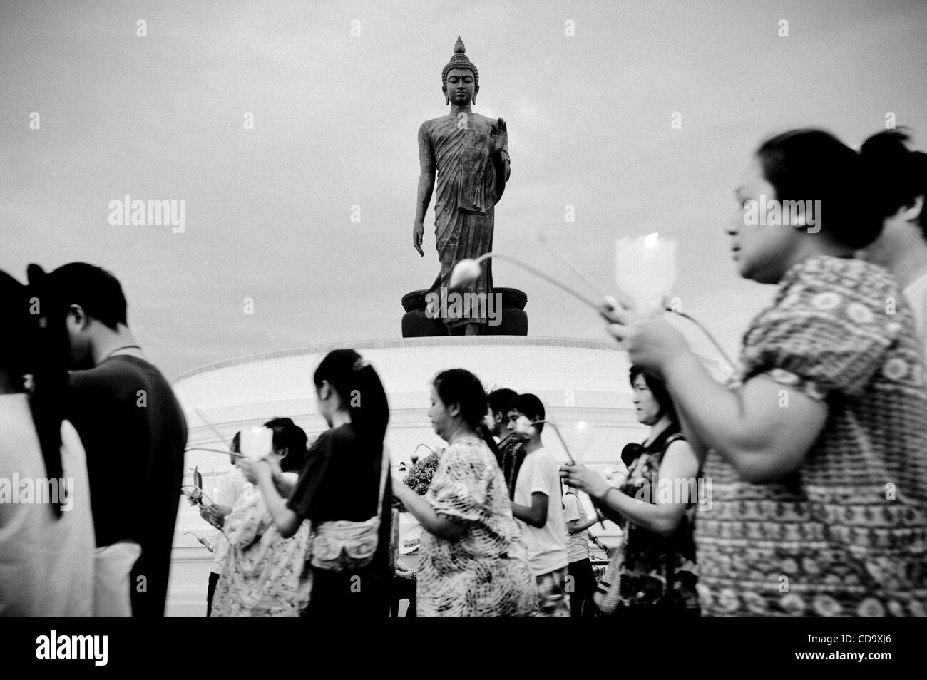 26. Juli 2010 - Nakhon Pathom, Thailand - Thais halten Kerzen in einem Outdoor-Prozession um eine 15,87 m hohe Buddha-Statue buddhistischen Fastenzeit tagsüber an Phutthamonthon. Die Statue gilt als der höchste frei stehende Buddha-Statue der Welt. Phutthamonthon ist ein buddhistischer park Stockfoto