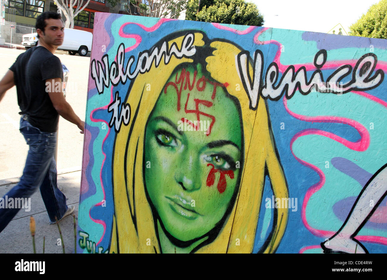 3. Februar 2011 - Venice, Kalifornien, USA - geht ein Mann vorbei an Venedig Künstler Jules Muck "Welcome to Venice" Malerei von Lindsay Lohan, die mit einem Hakenkreuz auf ihre Stirn und blutrote Tränen aus ihren Augen unkenntlich gemacht wurde. Viele Bewohner von Venice Beach sind unglücklich darüber, dass die unruhige Schauspielerin vor kurzem Mov hat Stockfoto