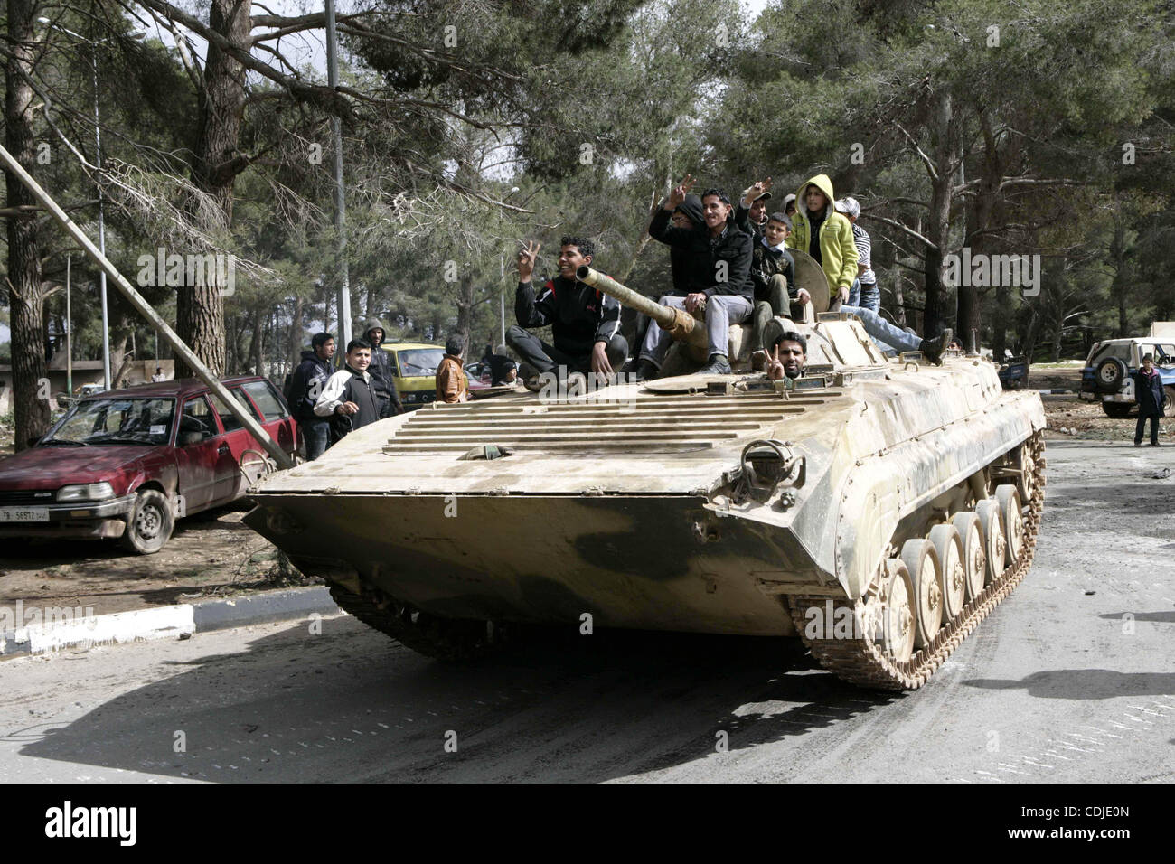 Anti-Regierungs-Demonstranten, Victory-Zeichen, wie sie auf einem Panzer in der Nähe einen Platz stehen, wo Menschen in ALbedi Stadt, Libyen, 24. Februar 2011 protestieren. Tausende von Libyern feierten die Befreiung von der östlichen Stadt Bengasi von der Herrschaft von Muammar Gaddafi, der berichtet wurde, dass se Stockfoto