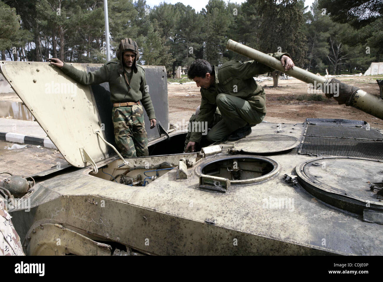 Anti-Regierungs-Demonstranten stehen auf einem Panzer in der Nähe einen Platz, wo Menschen in ALbedi Stadt, Libyen, 24. Februar 2011 protestieren. Tausende von Libyern feierten die Befreiung von der östlichen Stadt Bengasi von der Herrschaft von Muammar Gaddafi, der berichtet wurde, um ein Flugzeug zu bombardieren auf geschickt haben Stockfoto