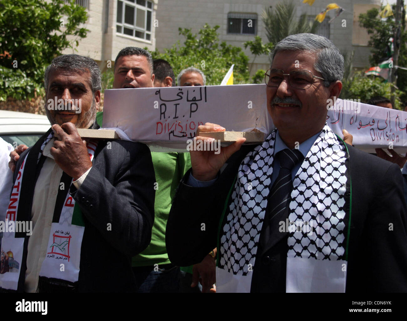 Schauen-Alikes Palestinian Authority President Mahmud Abbas (R) und Hamas-Führer Khaled Meshaal tragen einen mock Sarg für den Tod der palästinensischen politischen Abteilung während einer Kundgebung von Anhängern von Abbas' Fatah-Partei und Meshaals Hamas islamische Gruppe am 6. Mai 2011, in der West Bank-villa Stockfoto