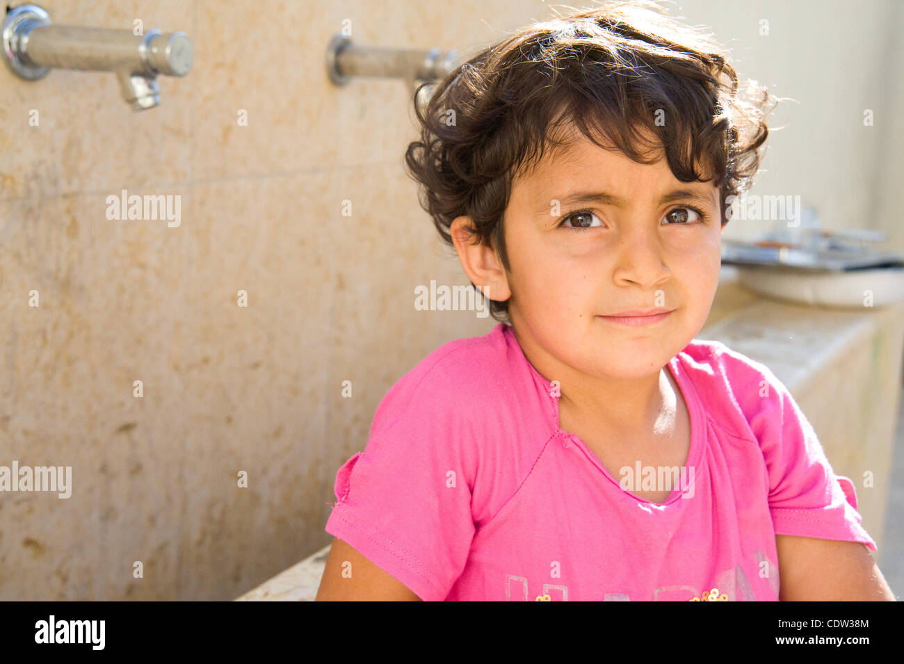 25. Juni 2011 - Amman, Jordanien - 25. Juni 2011, Amman, Jordanien - wäscht ein junges Mädchen ihre Hände an einem outdoor Wasserhahn auf dem Gelände der lateinischen Kirche in Misdar in Amman, Jordanien. Sie und andere christliche Community-Mitglieder hatten früher für eine wöchentliche Besprechung von Freiwilligen, die im Zusammenhang mit th organisiert versammelt. Stockfoto