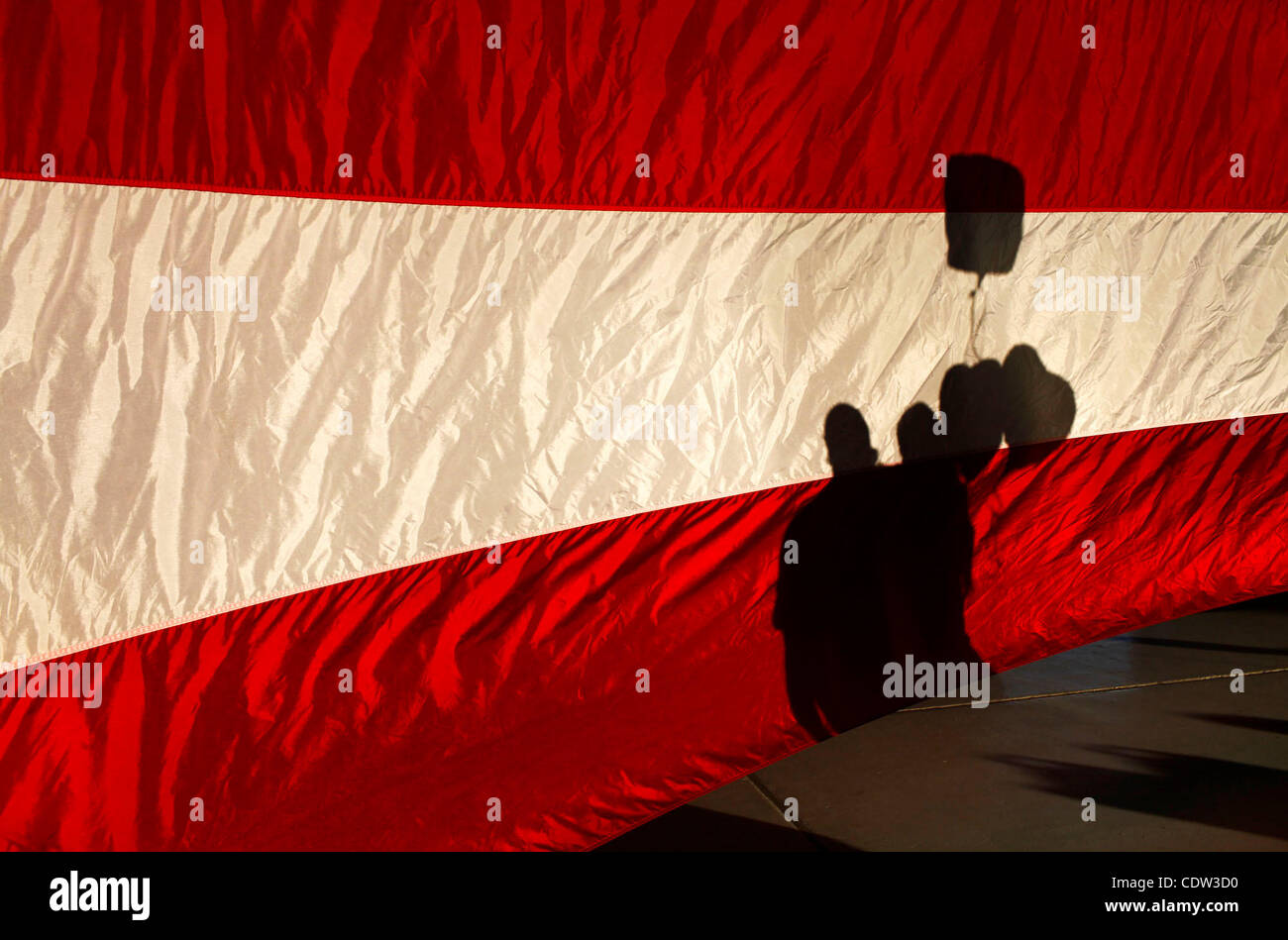 2. Juli 2011 - Whidbey Island, Washington, USA - Silhouette hinter eine 35-Fuß-amerikanische Flagge, ist ein paar nach der Ehemann Rückkehr aus einer achtmonatigen Bereitstellung im Nahen Osten auf Whidbey Island Naval Air Station vereint. (Kredit-Bild: © Jordan Stead/ZUMAPRESS.com) Stockfoto