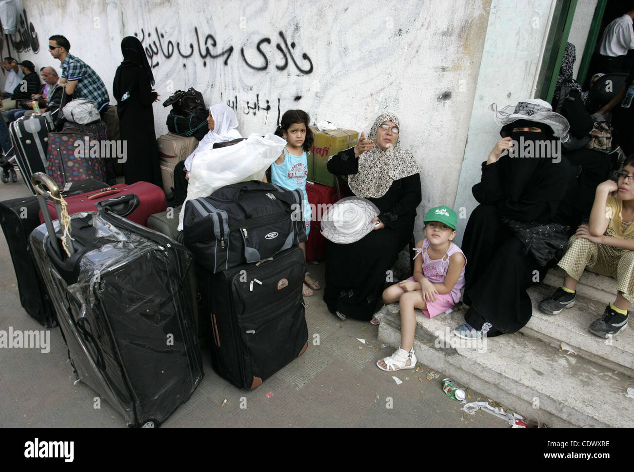 Palästinenser sitzen in der Nähe ihres Gepäcks, während sie darauf warten, in Ägypten über den Grenzübergang Rafah im südlichen Gazastreifen am Sep 12, 2011 zu überqueren. Foto von Ari Rahim Khatib Stockfoto