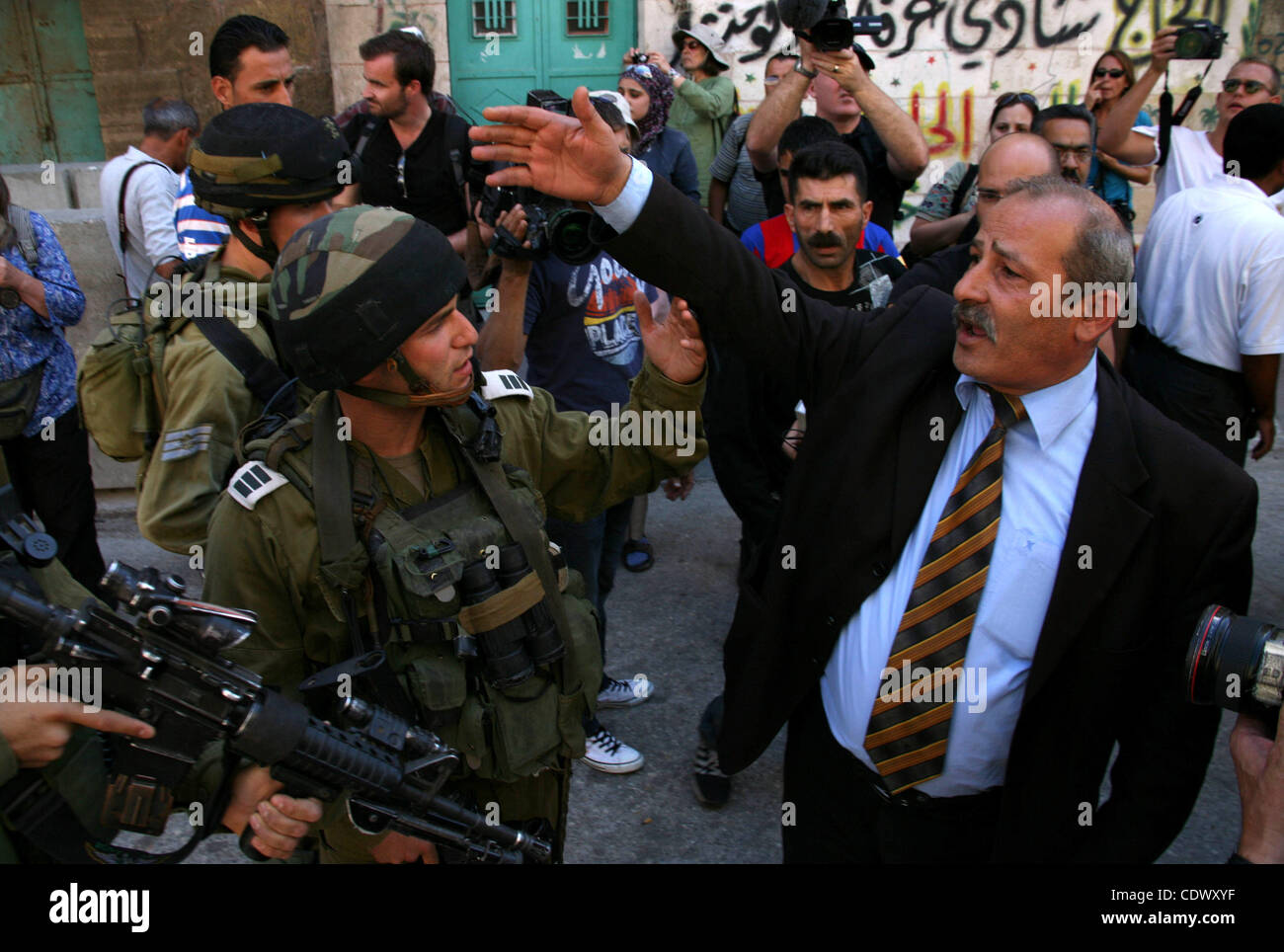 Ein palästinensischer Mann streitet mit israelischen Soldaten während einer Kundgebung gegen die Schließung der Shuhada Straße in Hebron, die Hauptschlagader, die durch einen israelischen militärischen Kontrollpunkt in der Mitte von Westjordanland Stadt von Hebron Sep 14, 2011 blockiert. Palästinenser demonstriert anspruchsvolle Bewegungsfreiheit in ihrer Stadt Stockfoto