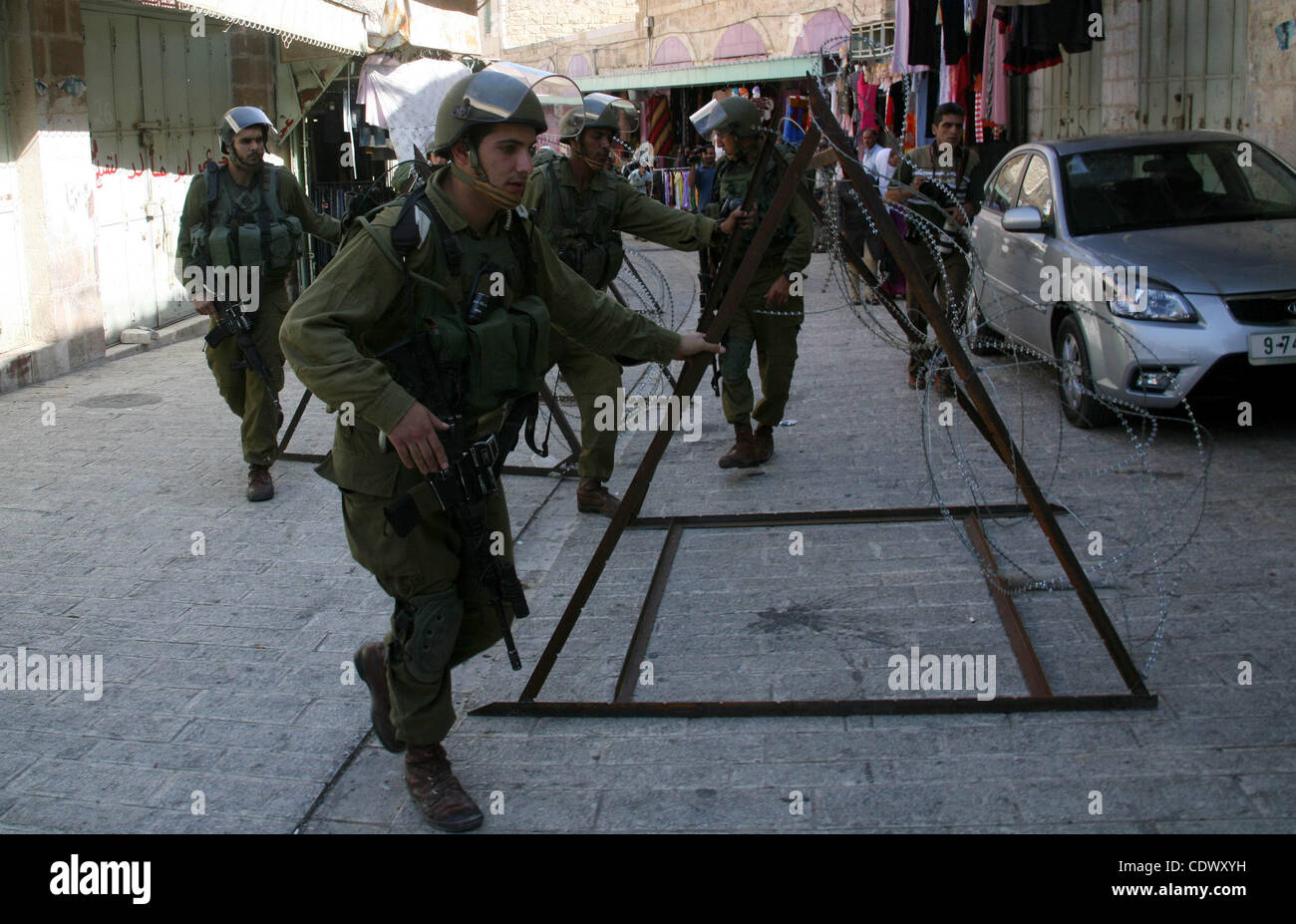 Israelische Soldaten in der Nähe der Straße während einer Kundgebung gegen die Schließung der Shuhada Straße in Hebron, die Hauptschlagader, die durch einen israelischen militärischen Kontrollpunkt in der Mitte von Westjordanland Stadt von Hebron Sep 14, 2011 blockiert. Palästinenser demonstriert anspruchsvolle Bewegungsfreiheit in ihrer Stadt wie alle Straßen le Stockfoto