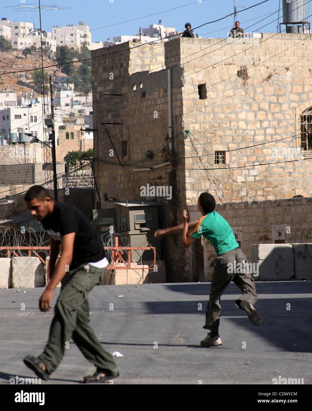 Palästinensische Jugendliche Steinwurf gegen israelische Soldaten während einer Protestaktion in der Westbank-Stadt Hebron 21. September 2011, wie palästinensische Präsident Mahmud Abbas bereitet sich auf einen formellen Antrag auf Palästina das 194. Mitglied der Vereinten Nationen trotz des Widerstands der USA und Israels zu übermitteln. Pho Stockfoto