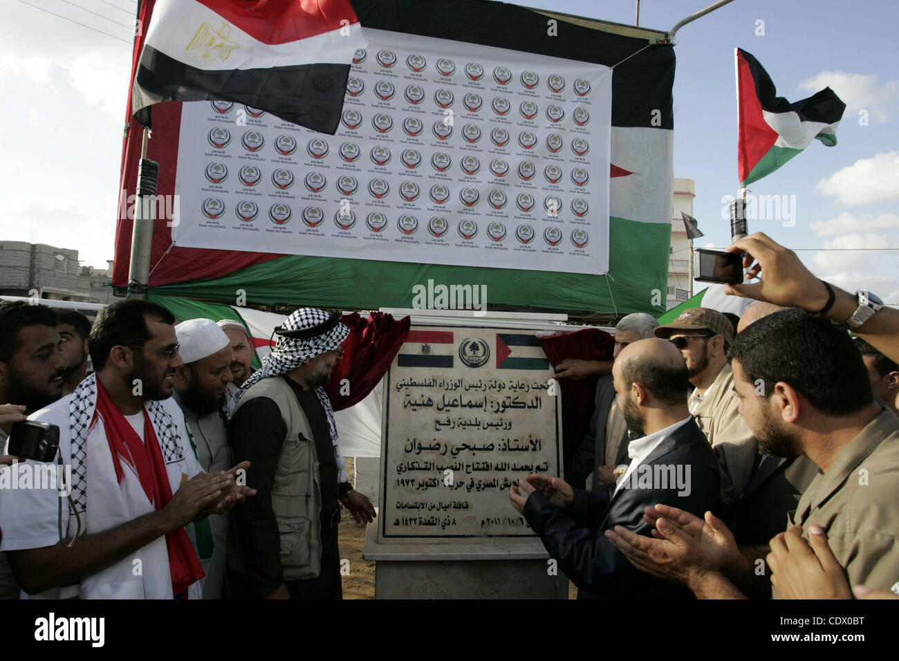 Palästinenser und die Mitglieder des "Miles Smiles 6' Hilfe Konvoi nehmen Sie Teil an der feierlichen Eröffnung des Denkmals für die Ägypter getötet während des 6 arabisch-israelischen Krieges 1973 in Rafah, südlichen Gazastreifen am Okt. 6,2011. Foto von Ari Rahim Khatib Stockfoto