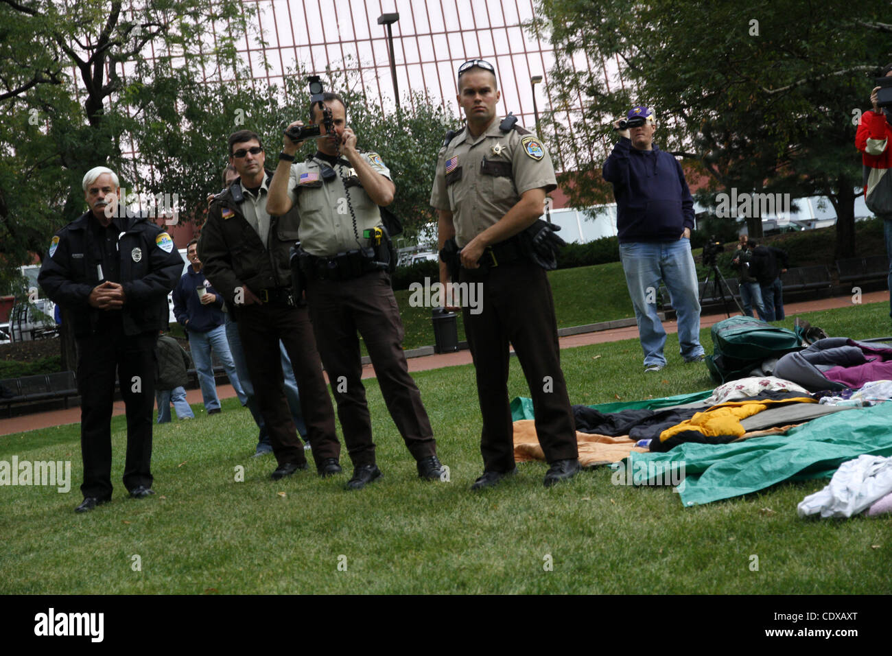 Grafschaft Stellvertreter film "Occupy MN" Demonstranten, wie sie klare Zelte auf einer Wiese außerhalb der Hennepin County Government Center, Minneapolis, Minnesota, 15. Oktober 2011 zu bringen. Stockfoto