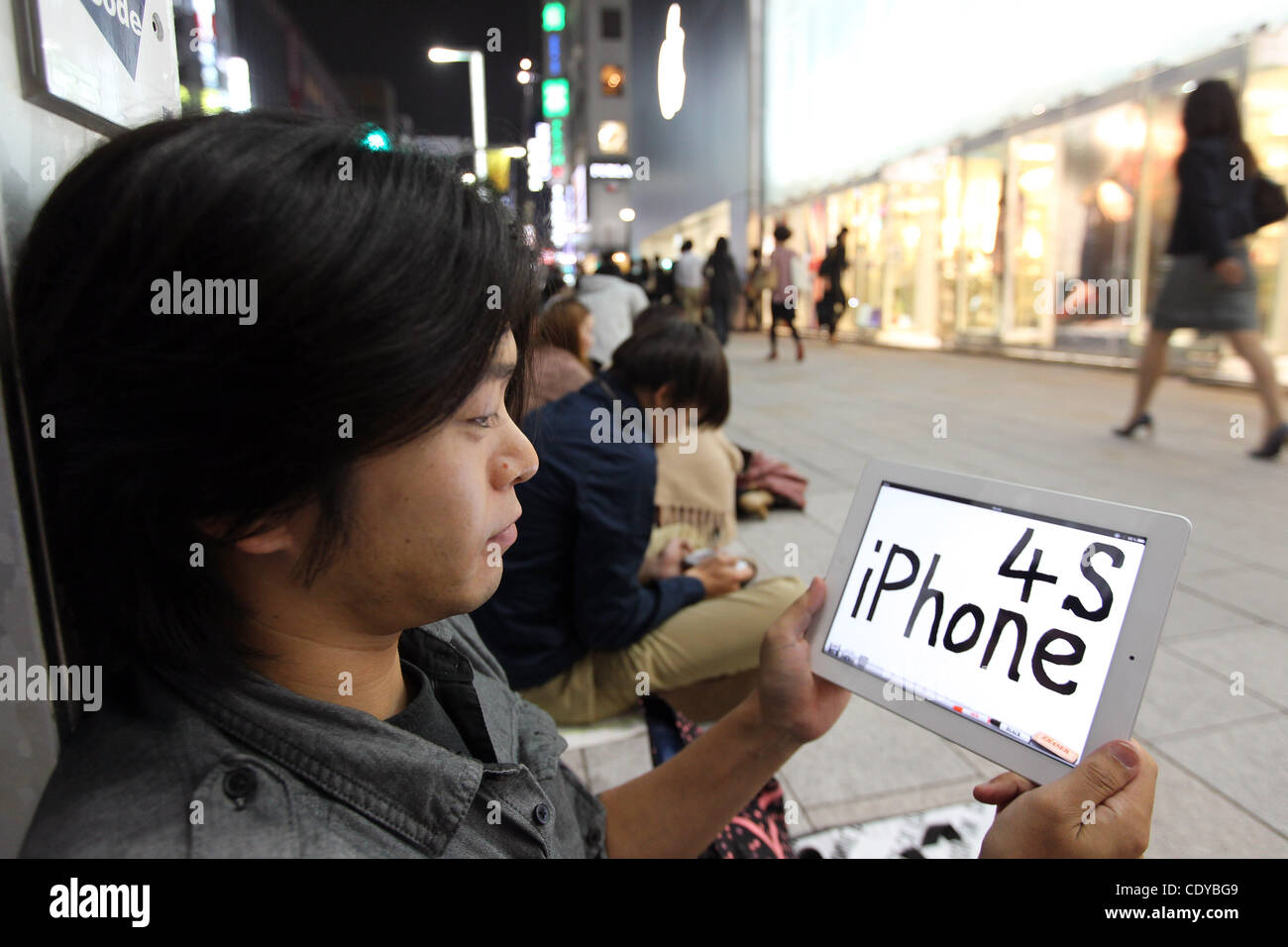 13. Oktober 2011 - Tokyo, Japan - mehr als 100 Kunden Line-up vor dem Apple Store in Ginza-Viertel in der Nacht, bevor das iPhone 4 s auf Verkauf in Tokio, Japan geht. iPhone 4 s wird gleichzeitig in 7 Ländern veröffentlicht werden. iPhone 4 s wird von Softbank und AU, 2 Träger für das erste t verkauft werden Stockfoto