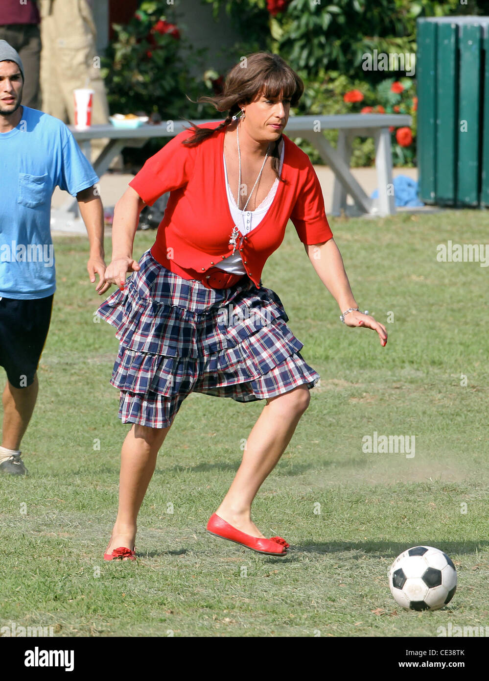 Adam Sandler spielt Fußball gekleidet wie eine Frau in einer roten Jacke  und Rock, auf dem Film Standort für den Spielfilm "Jack and Jill" in einem  Park in Hollywood. Los Angeles, Kalifornien -
