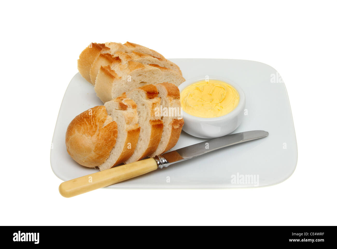 Knuspriges Brot und Butter in einem Töpfchen mit einem Messer auf einen Teller isoliert gegen weiß Stockfoto
