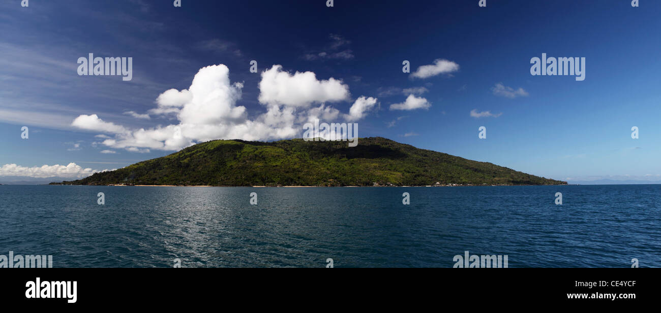 Die grünen üppigen Insel Nosy Komba betrachtet von einem Segelboot unter blauem Himmel und weißen dicken Wolken. Madagaskar. Stockfoto