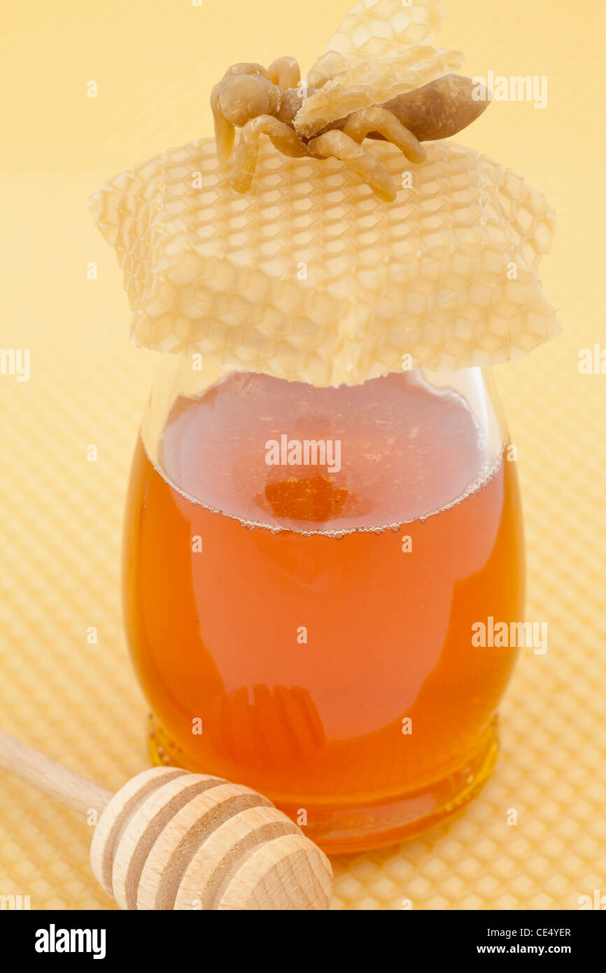 Honig im Glas mit einem Holzlöffel auf Hintergrund Stockfoto