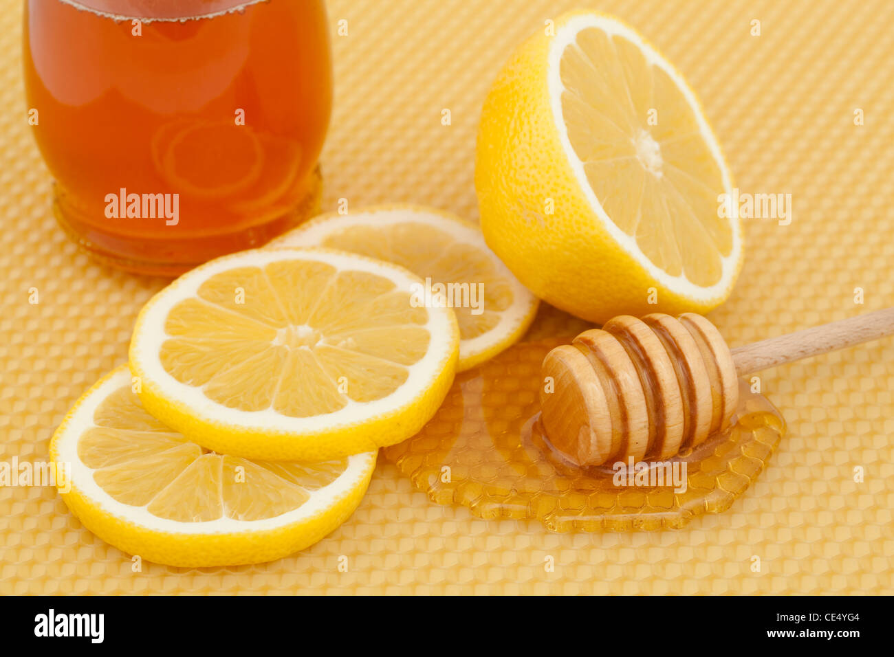verschüttete Honig mit Scheiben Zitrone auf Hintergrund Stockfoto