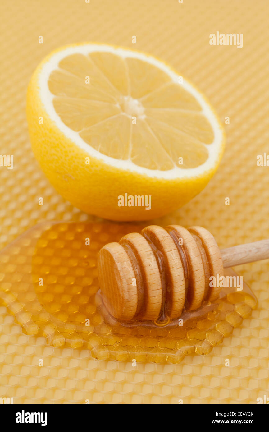 verschüttete Honig mit halben Zitrone auf Hintergrund Stockfoto
