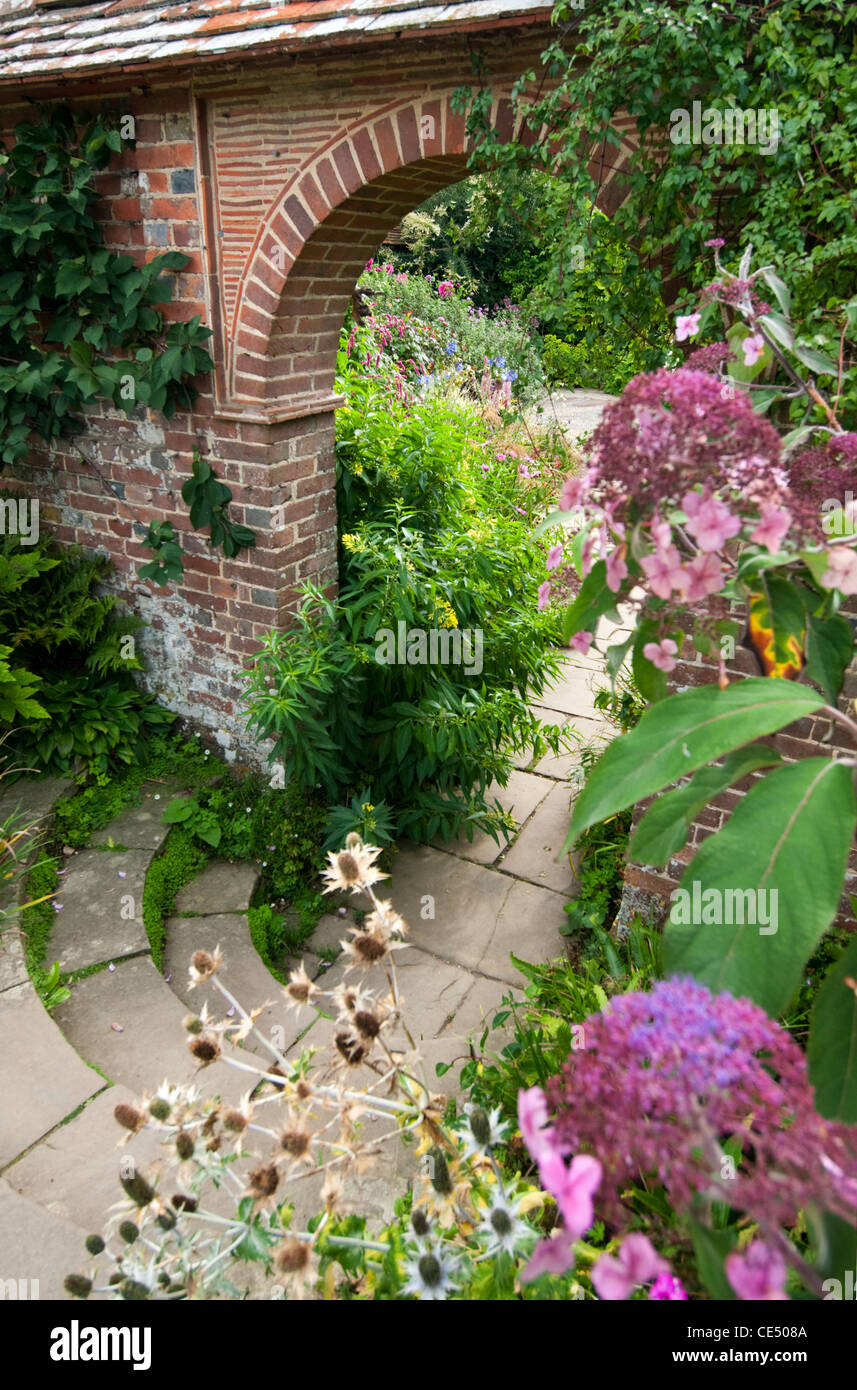 Ein Torbogen durch einen ummauerten Garten. Stockfoto