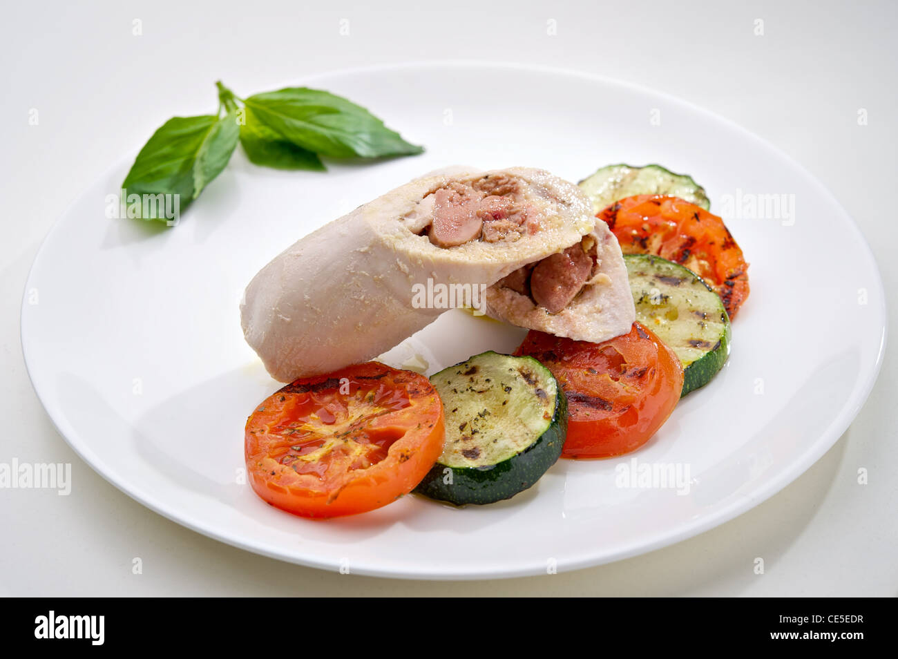 Gedämpftes Huhn Schnitzel mit gebackenem Gemüse auf runden weißen Teller serviert Stockfoto