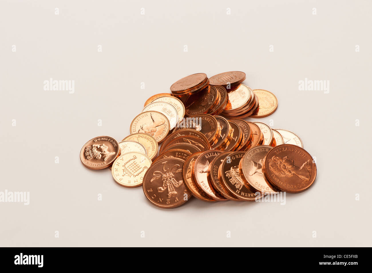 ein Haufen englischer Kupfermünzen auf weißem Hintergrund Stockfoto