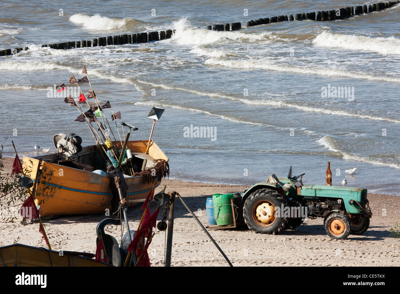 Angelboot/Fischerboot und Traktor am Strand in Niechorze. Angeln an der Westküste der Ostsee, Polen. Zeitigen Frühjahr. Stockfoto