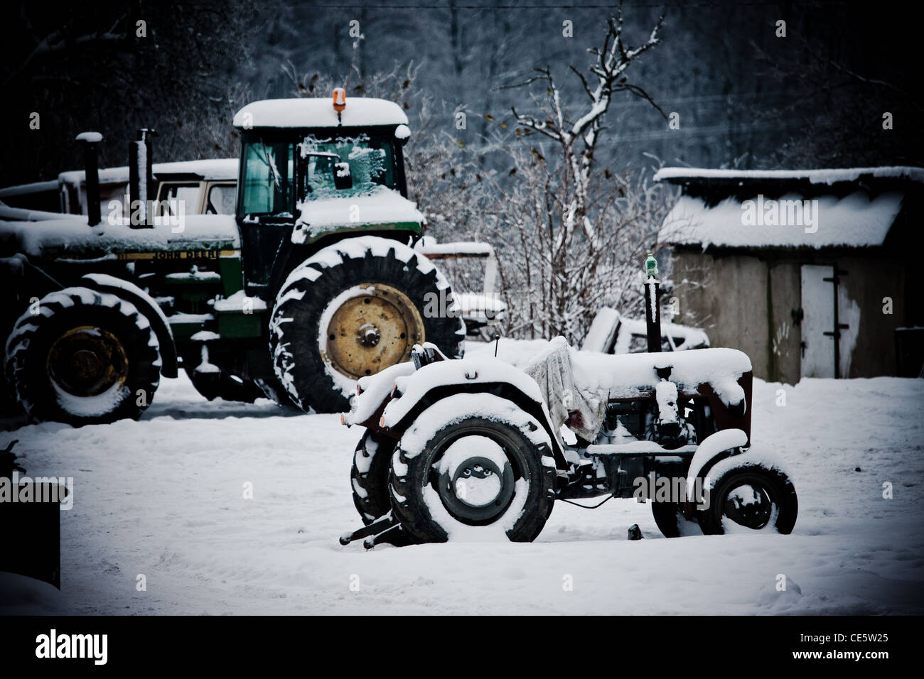 Zwei Traktoren mit Schnee bedeckt, in dem polnischen Dorf "Śliwin". Polnische Landschaft Winterlandschaft. Stockfoto