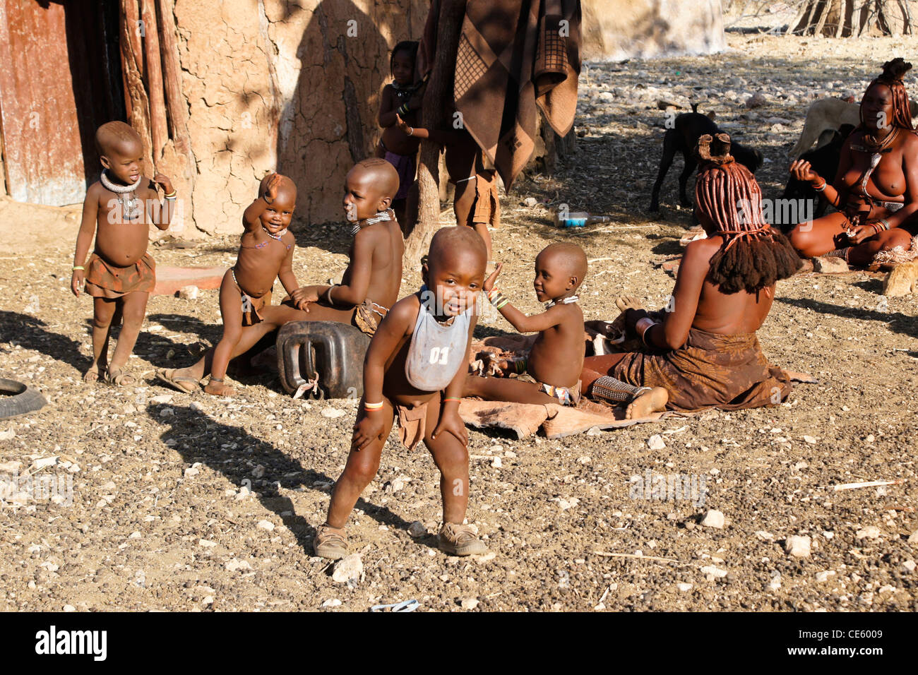Himba-Frauen und Kinder in ihrem Dorf in der Nähe von Opuwo, Namibia Stockfoto