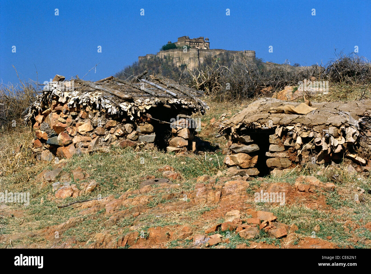 Alte Festung auf dem Hügel mit Steinhütten im Vordergrund Sariska Rajasthan Indien Stockfoto