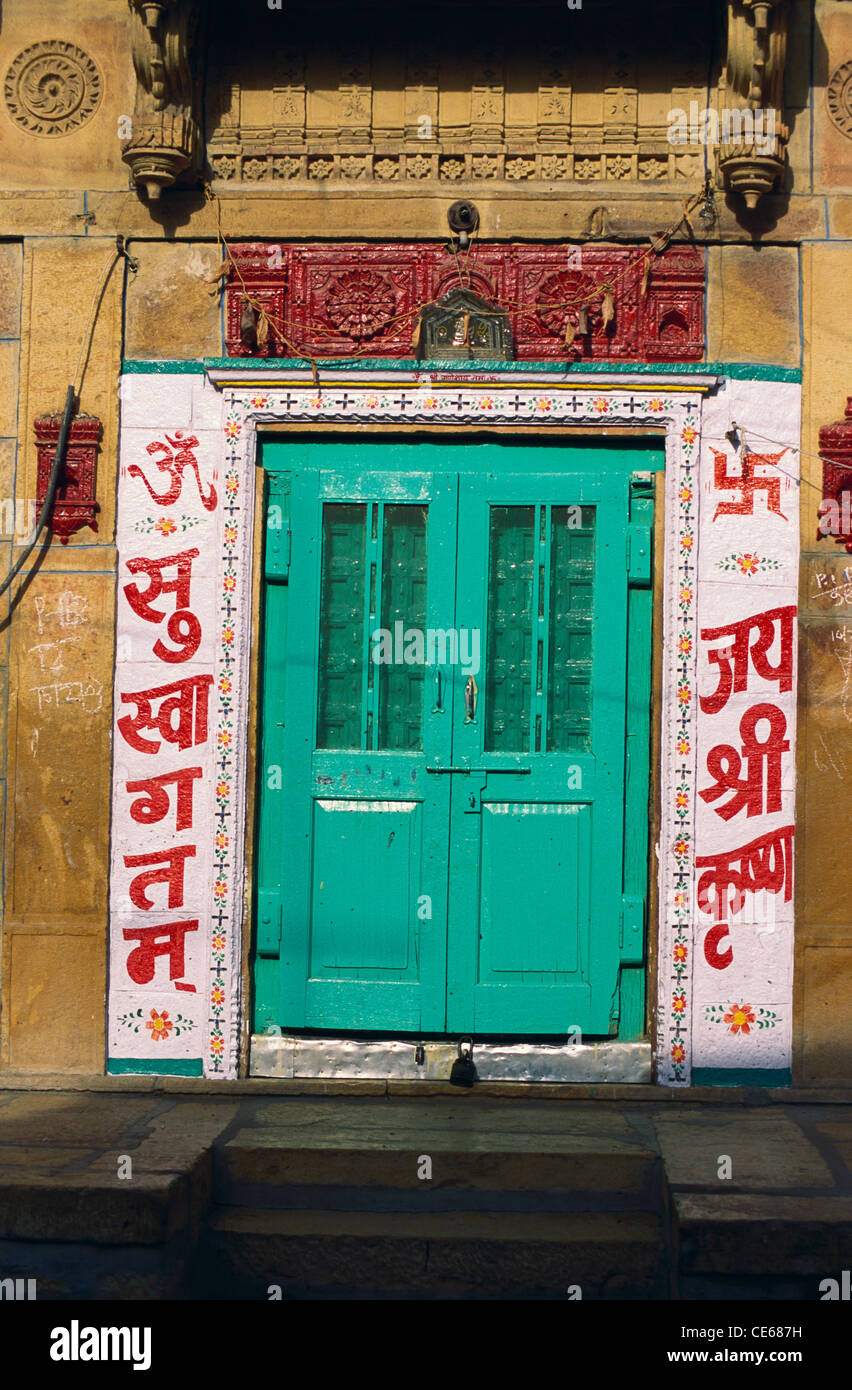 Geschlossene Tür grün gemalt; Wand gemalt Willkommen und Jai Shree Krishna und Suswagatam; Jaisalmer; Rajasthan; Indien; Asien Stockfoto