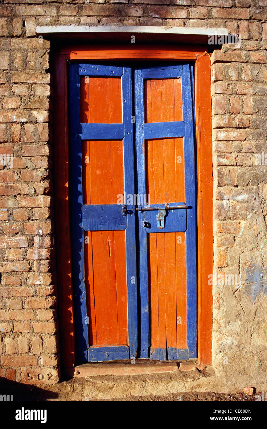 Geschlossene ländliche hölzerne Tür, die blau und safran gemalt wird; Pune; Maharashtra; Indien; Asien Stockfoto