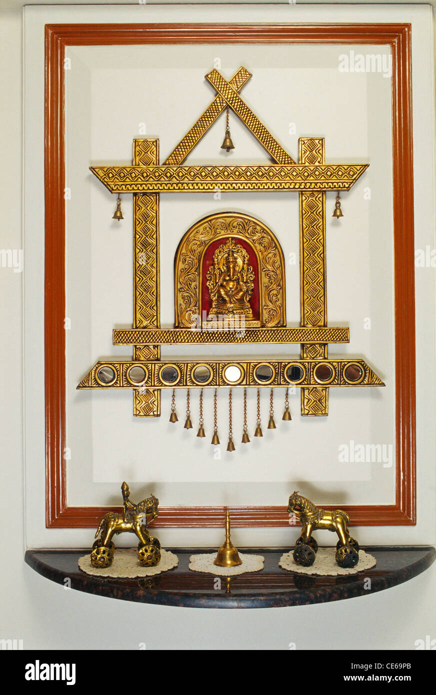 Ganesh Tempelaltar im Wohnzimmer; goldene Dekoration und Tempelglocken; Bombay; Mumbai; Maharashtra; Indien; Asien Stockfoto