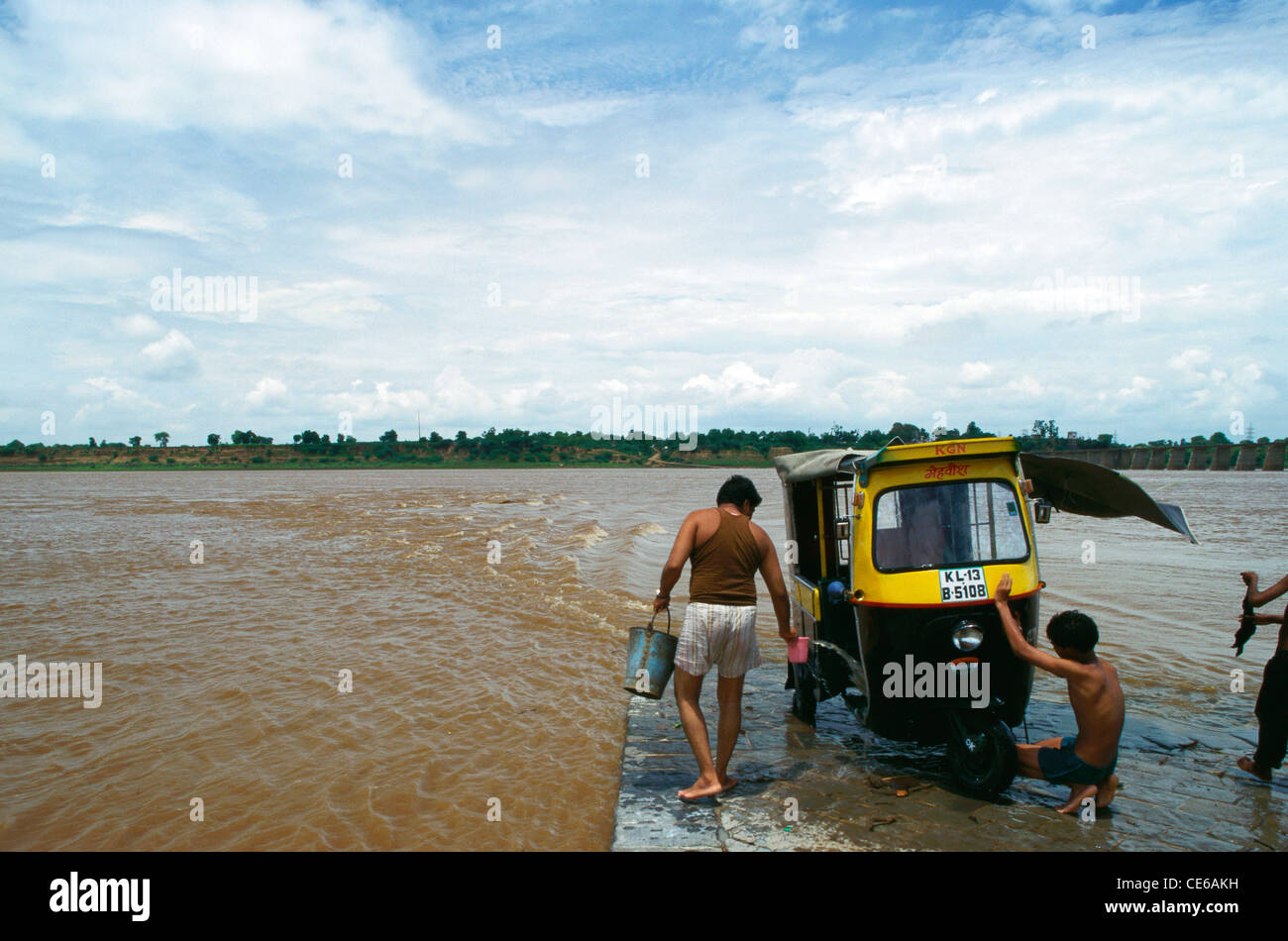 Männer waschen Auto-Rikscha in Narmada Fluss; Rajghat; Badwani; Madhya Pradesh; Indien Stockfoto