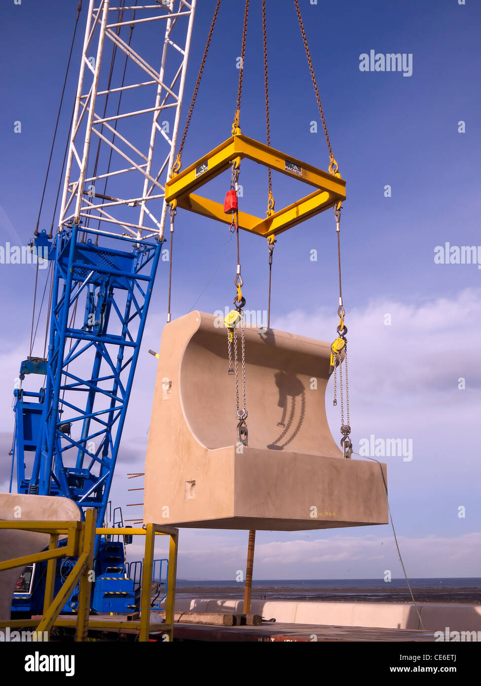 Ein Teil der vorgegossenen konkrete Welle Wand wird aus geladen mit Kran für den Wiederaufbau der Ufermauer Redcar Cleveland UK Stockfoto